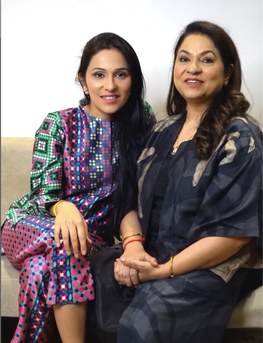 Mom and Nidhi sitting together, hands clasped
