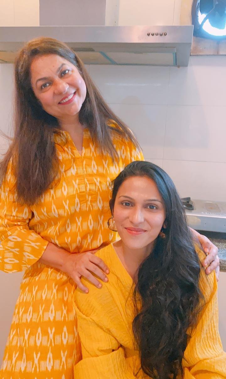 Mom with a hand on her daughter’s shoulder in the kitchen