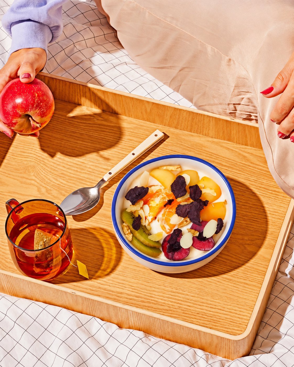 A fruit and yogurt breakfast bowl on a wooden tray
